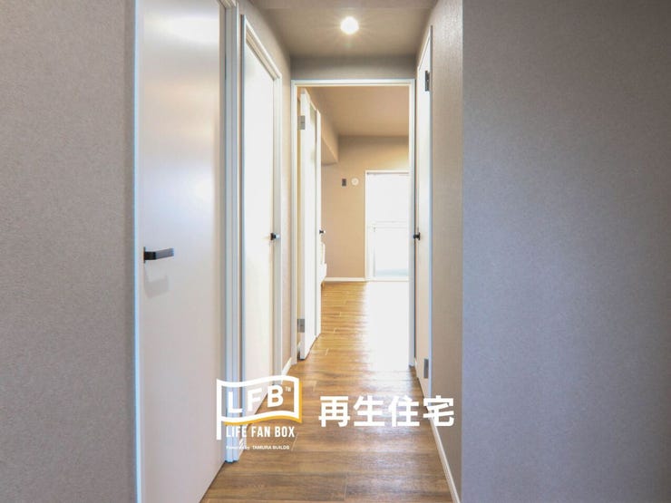 リビングへ続く廊下は、プライベート空間への期待感を高める落ち着いたデザイン。各洋室へと繋がるドアは、明るい木目調で統一されており、住まい全体に一体感と温もりを与えます。