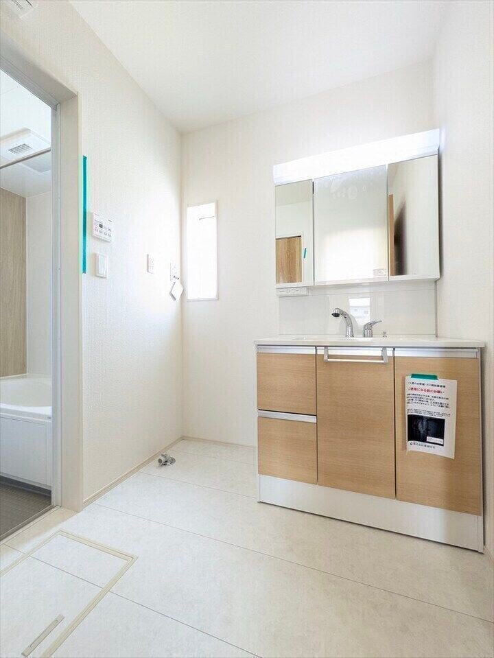 【同社施工例】窓付きの明るいランドリールーム。大きな3面鏡のついた洗面台は、ハンドシャワーがついているので朝の身支度もラクラク