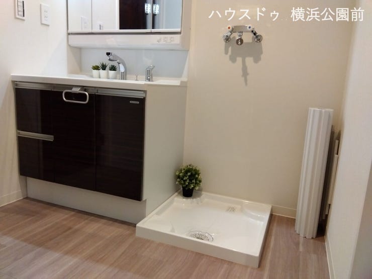 洗面台の隣は洗濯機置き場。洗面台のミラーは三面鏡になり、収納も可能です。