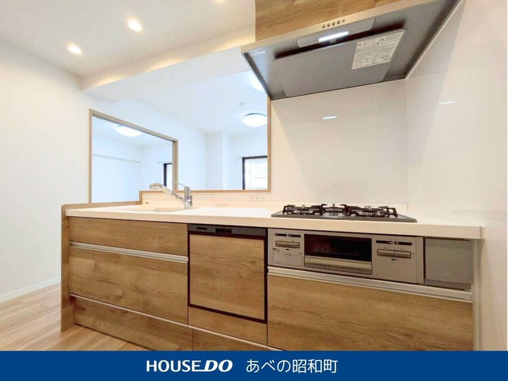 白い天板と木目調のキャビネットが調和した、やさしい印象のシステムキッチン。
リビングとつながるカウンターキッチンだから、家族との会話を楽しみながらお料理ができます。