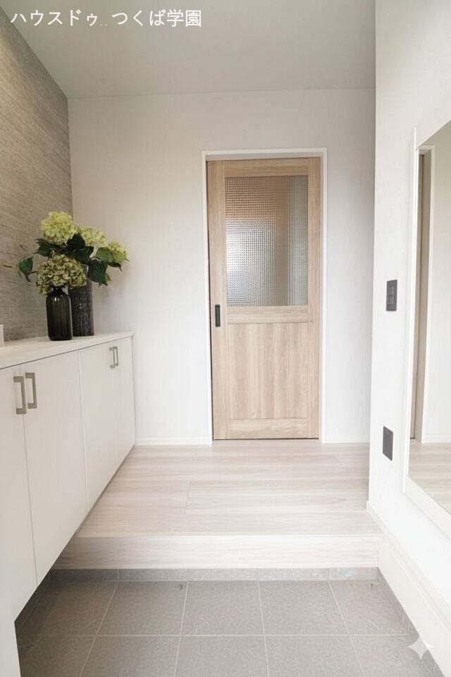 ベージュのフローリングとライトグレーのアクセントクロスがおしゃれな玄関です♪