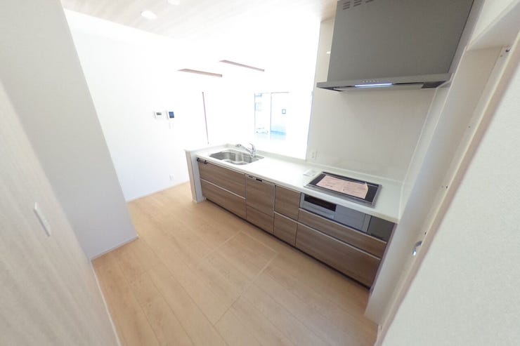 食器洗浄乾燥機付きの対面キッチンです。背面にカップボードを置いてもゆとりのあるスペースです。可動棚付きのパントリーもありキッチン周りをスッキリとご使用いただけます。(甲府市羽黒町 新築建売物件)