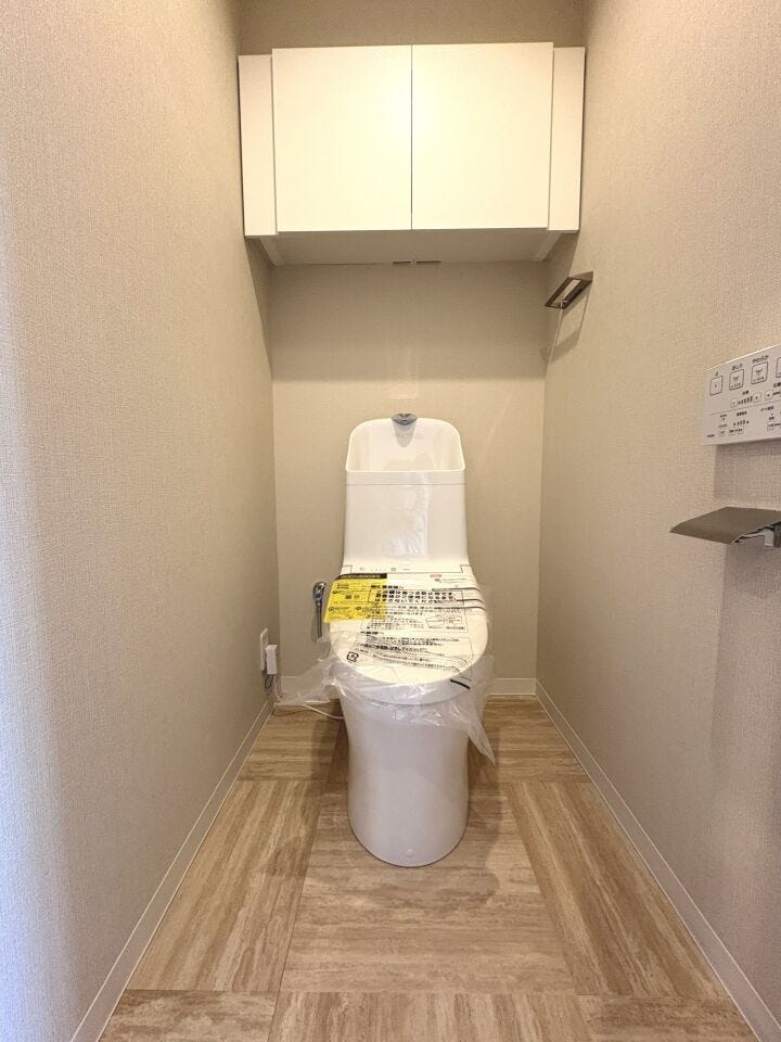 温水洗浄便座付トイレ。上部収納棚にはペーパーや掃除用品の保管も可能です。