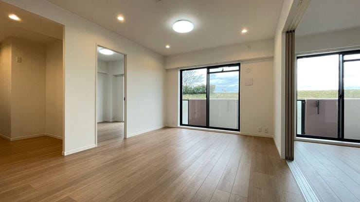 バルコニーからの光をいっぱいに取り入れる大きな掃き出し窓のあるリビング