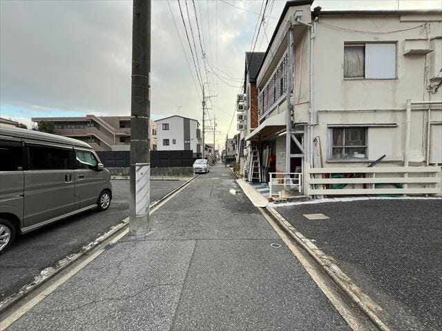 前面道路の向かいには、近隣の駐車場があり、狭い道路ですが、対面ですれ違った時に退避することができます。
(2025年11月21日撮影)