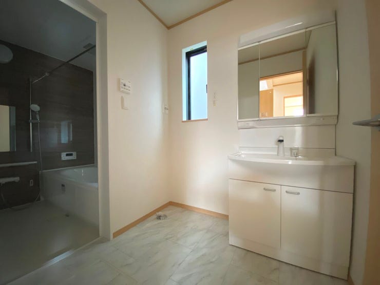 収納豊富な三面鏡の洗面化粧台。シャワー機能付きで衣類の手洗いや洗髪にも便利です。