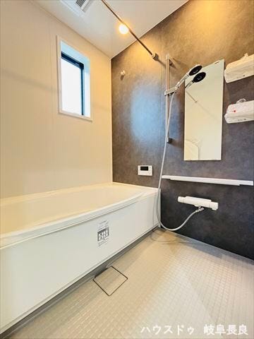 木目調の壁が落ち着いた印象を与えてくれる浴室です。棚や小物を置くスペースもついているので、シャンプーなどを置くのに便利ですね。