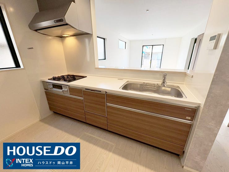 木の温もりを感じるデザインが素敵なシステムキッチン。ワイドなシンクや三口コンロはお料理の時間をより快適にしてくれますね。対面式なので、リビングで寛ぐ家族と笑顔を共有しながら家事が楽しめます!