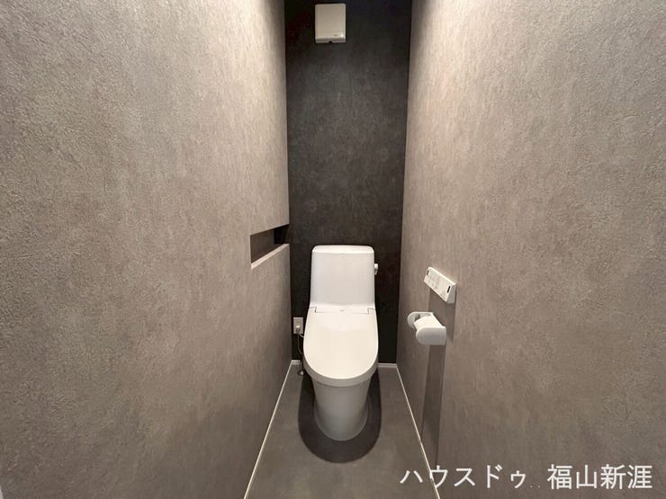 広々空間のお手洗い。収納棚もあり、壁のカラーも落ち着いていています。