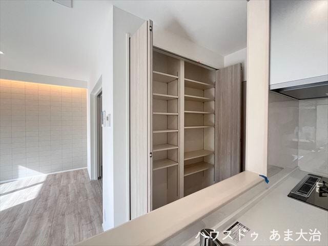 キッチン前通路にある大型収納は可動棚となっているので収納したい物の高さに合わせて高さを変えられます。リビング収納として活用できます。