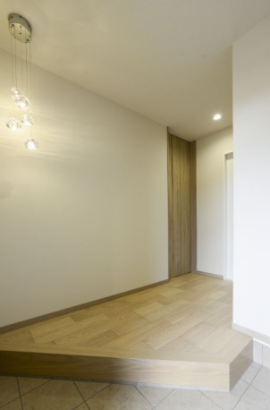 上がり框を斜めに設けた奥行きのある玄関ホール。ハイドアや雫をモチーフとしたペンダント照明が空間を上品に彩ります。