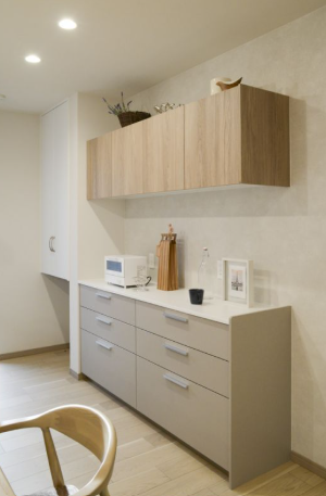 2色遣いのカップボードはウォール収納の木目が程よいアクセントに。背面の塗り壁風クロスも全体を調和させています。