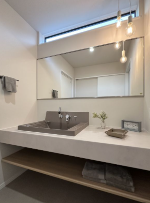 幅広のミラーと高さを変えたペンダント照明が目を惹く洗面コーナー。シンプルなカウンターと使い勝手の良い大型ボウルの組み合わせもこだわりポイントです。
