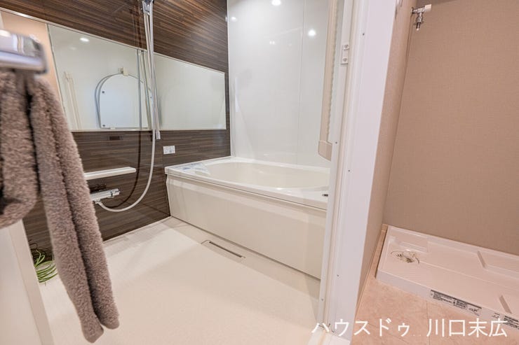 木目調のパネルが高級感を演出するバスルーム。雨の日や夜間の洗濯物乾燥に便利な浴室換気乾燥機を備え、快適なバスタイムと家事効率の両立を叶えます。