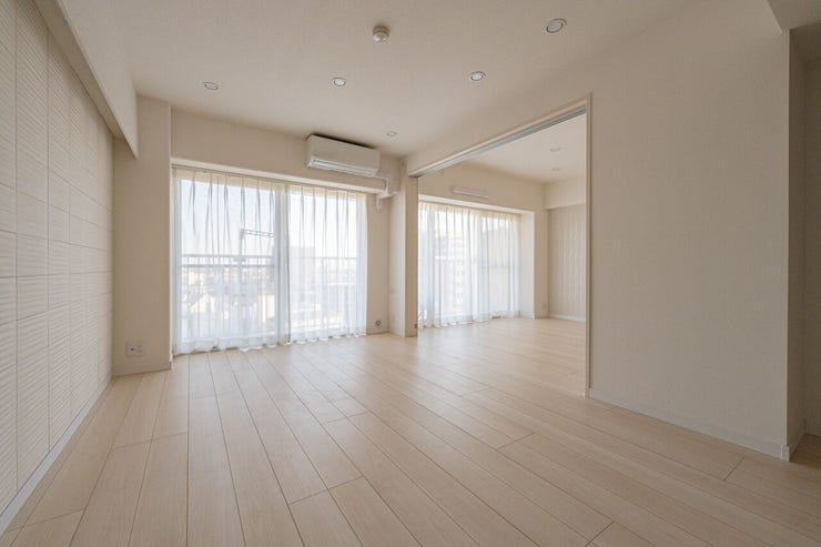 大きな窓から自然光が注ぎ込む、開放感あふれるリビング。フラットな床面が空間の広がりを強調し、どんなインテリアも合わせやすいシンプルで美しい仕上がりです。