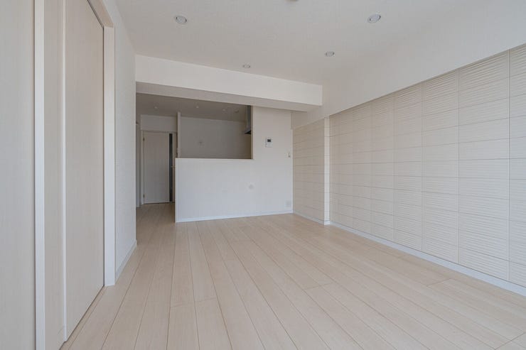 デザイン性と機能性を兼ね備えた壁面装飾が、リビングの格式を高めます。対面キッチンとのつながりを感じさせるレイアウトにより、家族の気配を感じながら過ごせる温かみのある空間です。