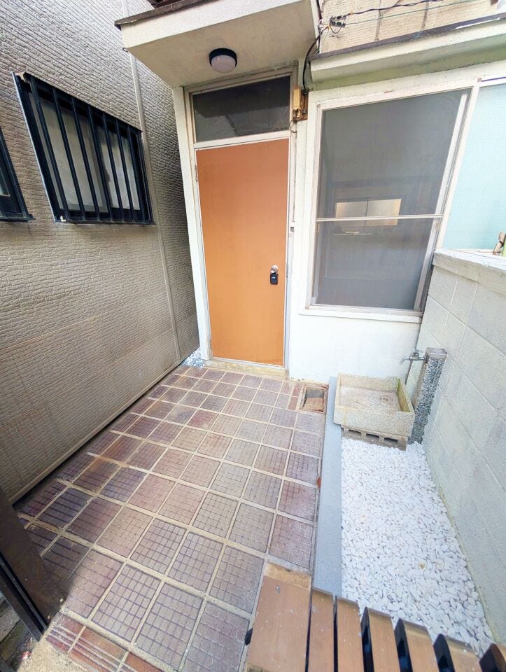 玄関前は屋根付きのタイル敷きで、自転車や荷物の出し入れがしやすい造りです。手洗い場もあり、外作業後の利用に便利です。日々の動線に配慮されたスペースです。