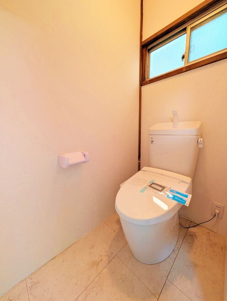 清潔感のあるトイレで、窓があるため換気もしやすい環境です。落ち着いた内装で、日常的に使いやすいスペースにまとまっています。