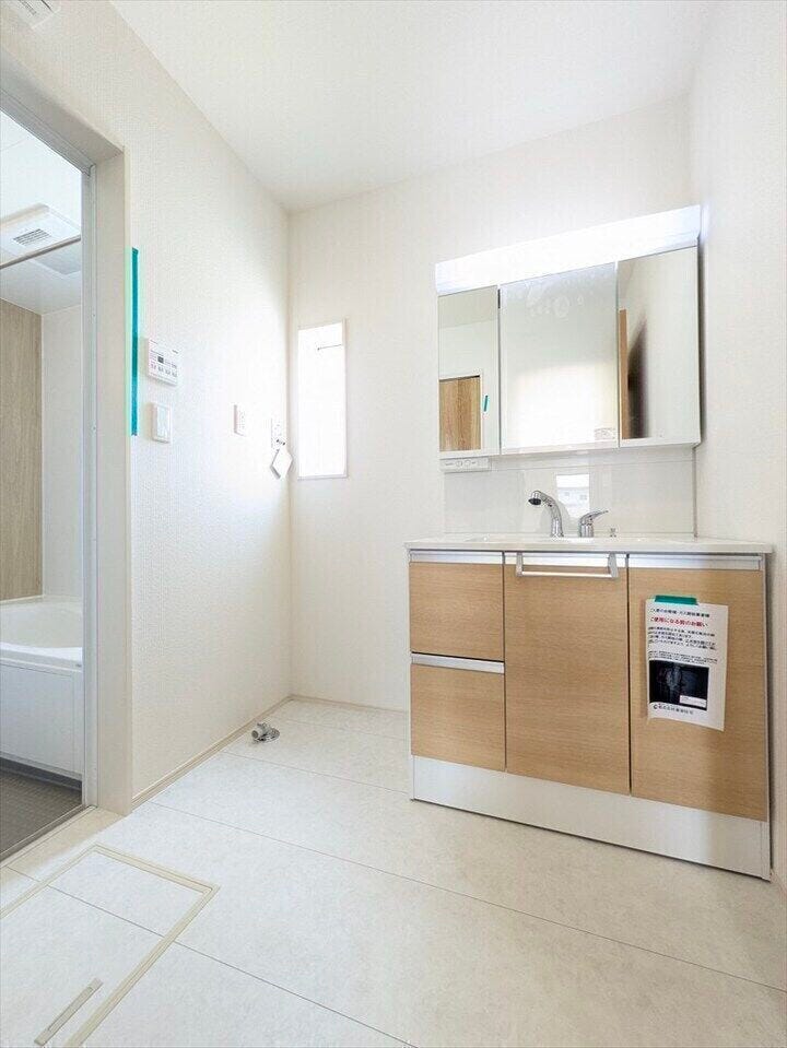 【同社施工例】窓付きの明るいランドリールーム。大きな3面鏡のついた洗面台は、ハンドシャワーがついているので朝の身支度もラクラク