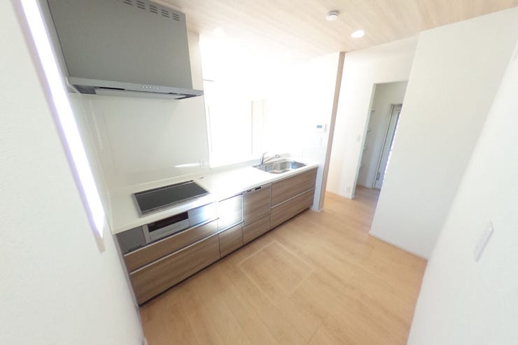 食器洗浄乾燥機付きの対面キッチンです。背面にカップボードを置いてもゆとりのあるスペースです。キッチン横には可動棚スペースもありキッチン周りをスッキリとご使用いただけます。(中央市西花輪 新築建売物件)