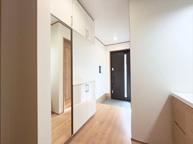 玄関:ホワイトを基調とした収納スペースがあります。ご家族分の靴をしまうことができます。すっきりと片付いた玄関で気持ちよくご家族をお出迎えすることができます。