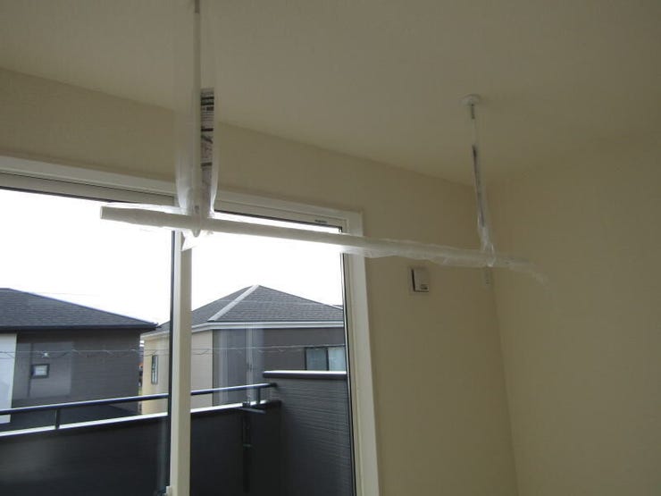 洋室に設置された室内物干し機で、天候を気にせず洗濯物を干すことができます。