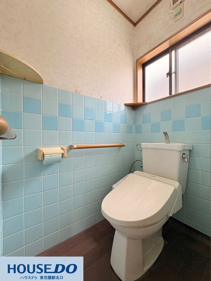 爽やかなブルーのタイル壁が印象的な明るいトイレ空間!立ち座りをサポートする木目調の手すりが設置されており、どなたでも安心感を持って使えます。窓からの自然換気もしやすく、清潔感を保ちやすいです☆