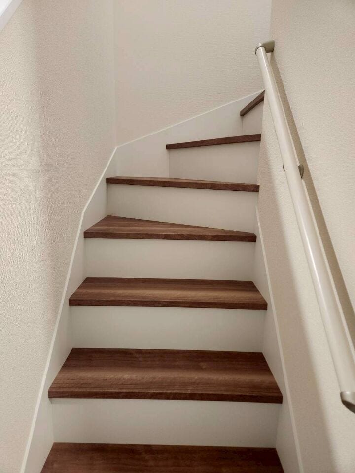 木目の踏み板と白壁のコントラストがお洒落な階段。