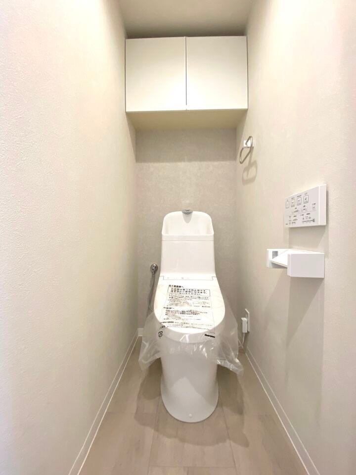 温水洗浄便座付トイレ。上部収納でペーパーや掃除用品の保管にも困りません。
