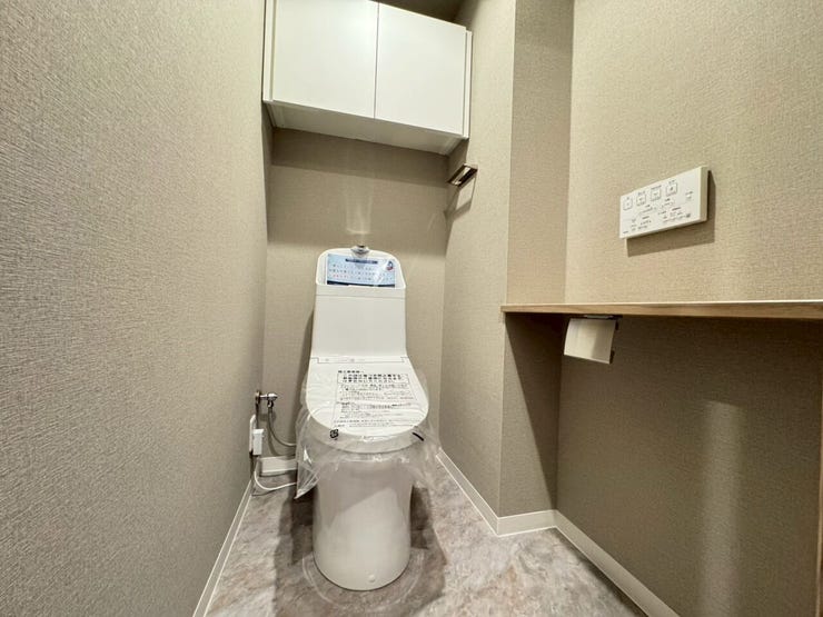 ≪トイレ≫
手洗い一体型のウォシュレットトイレ。背面には扉付きの収納棚も設置されています。