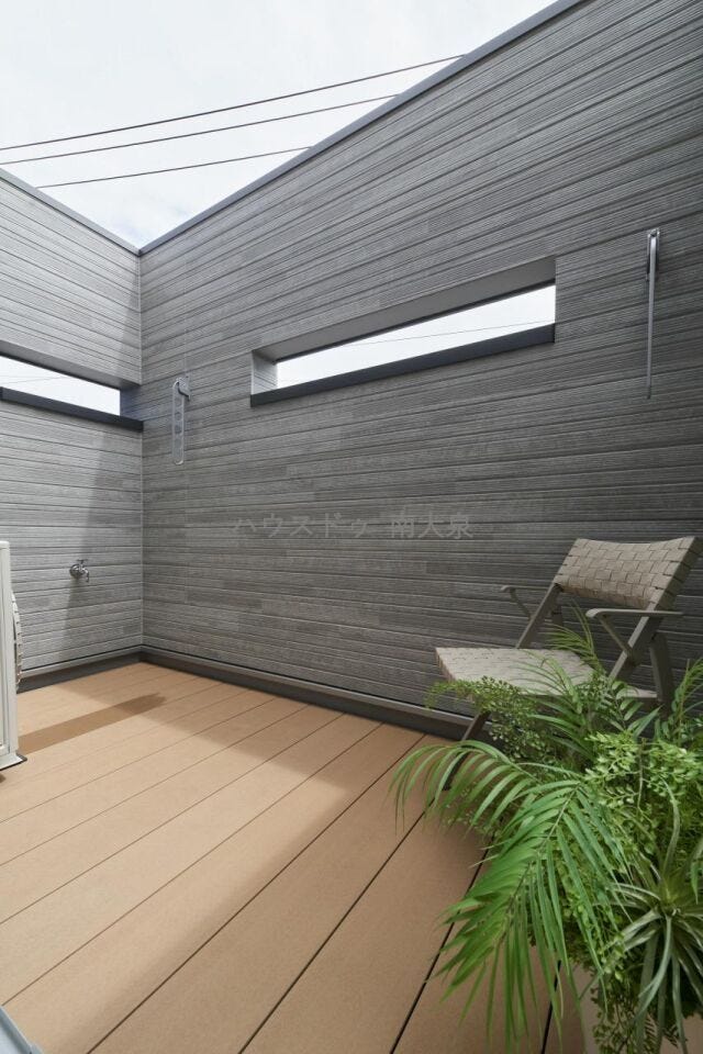 B号棟】ウッドデッキが設えられた、プライベートなバルコニー。外からの目線を遮りつつも、しっかりと光を取り込む設えが施されたプライベート空間