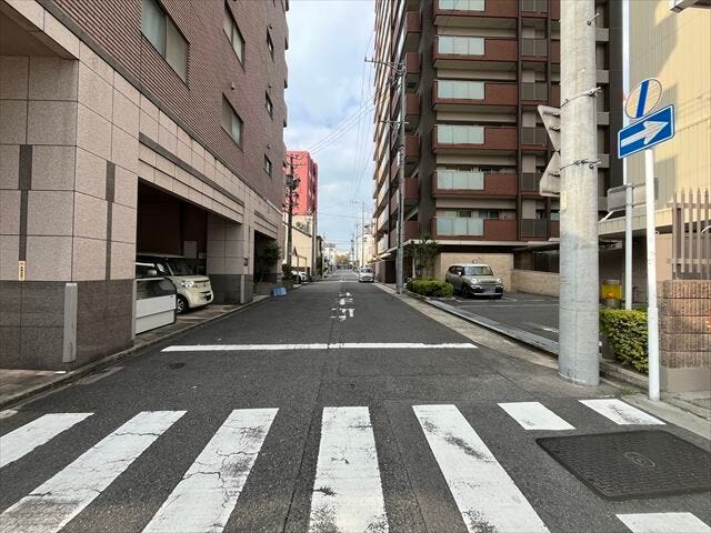 マンション南側前面道路です。機械式駐車場に面しています。東方面への一方通行となっています。