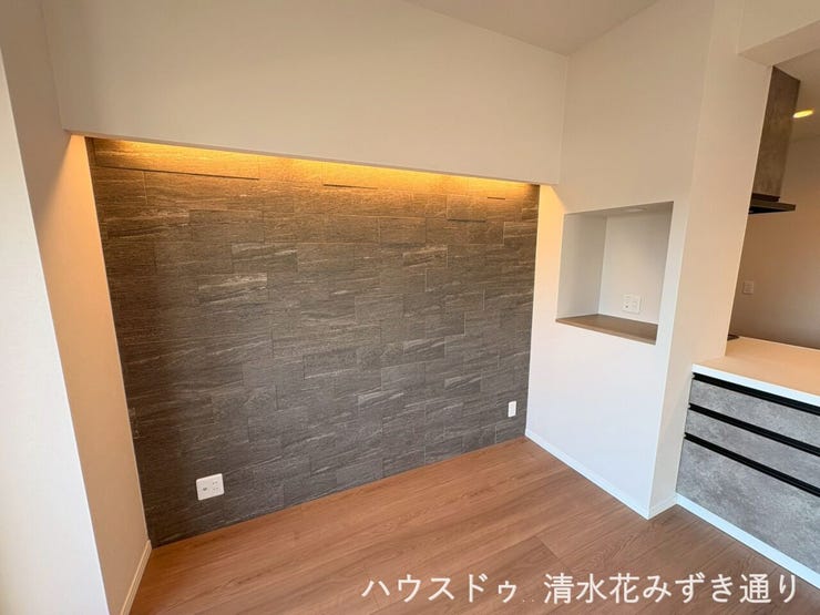 18.6帖LDK・・・リビングの一角には、石目調のアクセントウォールを採用。上部にはやわらかな間接照明が仕込まれ、夜になると上質なホテルライク空間へと表情を変えます◎