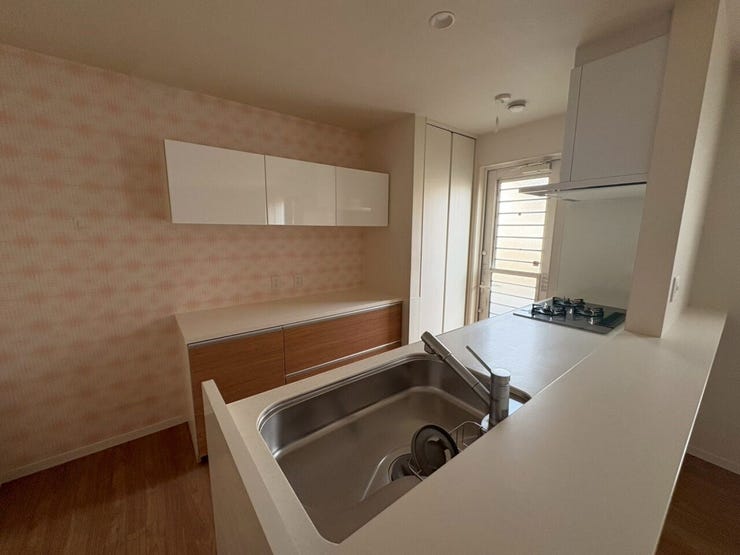 キッチンの後ろには収納スペースと作り付けのカップボードがあります♪壁のクロスがビタミンカラーで気分も上がります♪