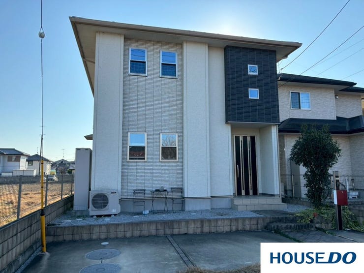 晴れた青空の下で、白い部分の外壁が光を受けて明るく見え、清潔感と開放感があります