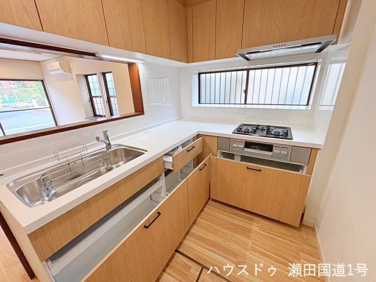 シンクとコンロが分かれたL字型のキッチンは、作業スペースが広く、複数人での調理もスムーズです。動線も短く、効率的に家事ができます。