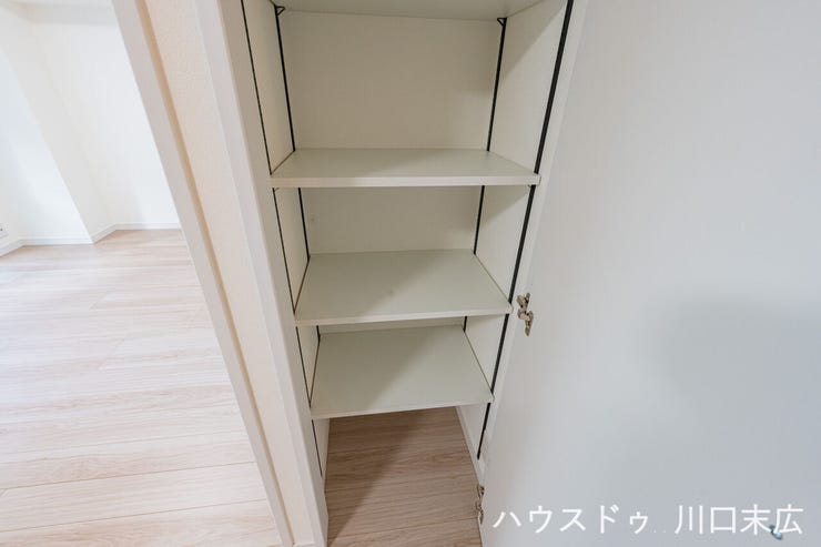 廊下に設けられた可動棚付きの収納スペース。日用品のストックや掃除用具など、家族で共用するアイテムの保管に重宝します。