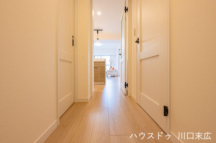 居住空間へと続く廊下は、木目の美しいフローリングが特徴。各居室への動線をスムーズにし、プライバシーにも配慮した設計です。