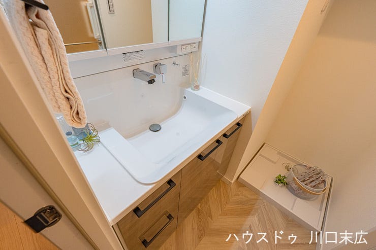 継ぎ目のないボウル一体型カウンターはお手入れが簡単。三面鏡裏には化粧品などの小物をすっきりと収納できるスペースを備えています。