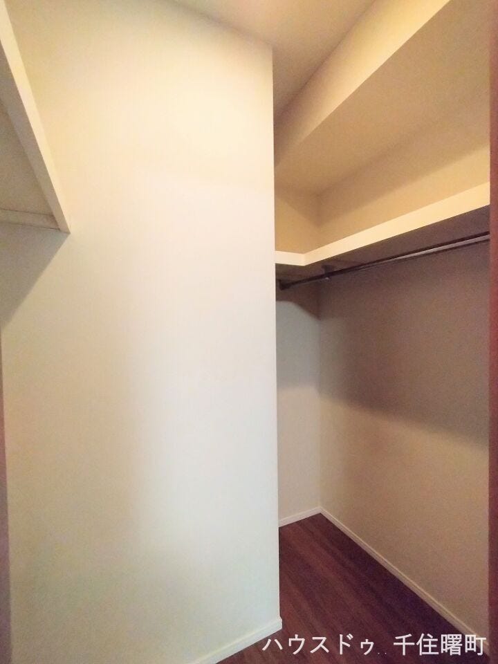 【衣類から季節物までたっぷり収納できるウォークインクローゼット】L字型にハンガーパイプが設置されており、洋服を効率よく掛けることができます。スーツケースなどの大きな荷物もすっきり片付きます。