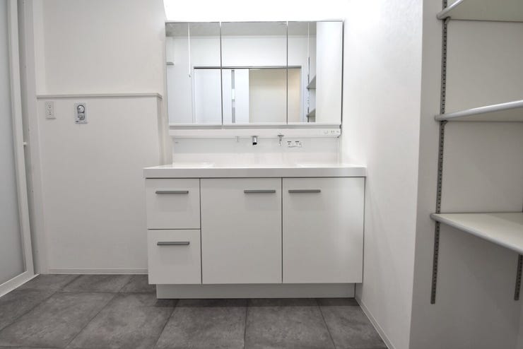 ワイドで収納豊富な三面鏡の洗面化粧台。洗面室には可動棚も設置されております。