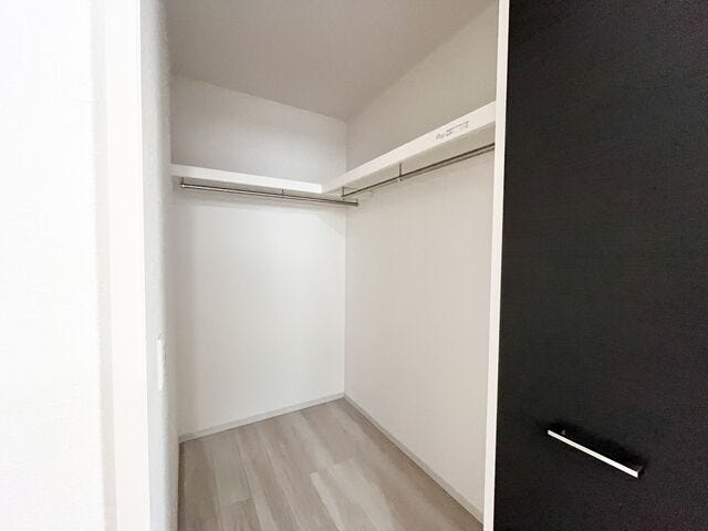 大型のWICです。ハンガーパイプと枕棚の設置があるので使いやすさアップ。床には衣装ケースを配置する事のできるゆとりもあります。