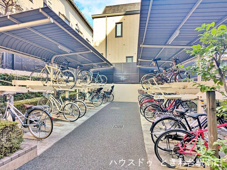 屋根付きの駐輪場を完備し、雨の日でも自転車を保管しやすい設計です。上下段ラックで整理され、通路幅も確保されているため出し入れがスムーズ。
