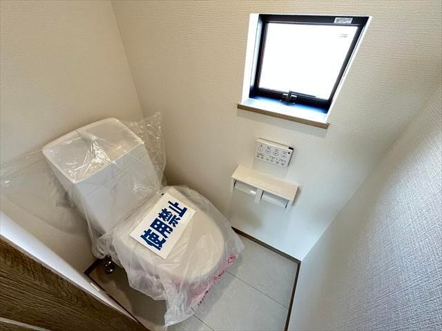 2階トイレ:小窓から自然光が入る個室。ペーパーホルダーには芳香剤を置いたり小物を置くことができますね。