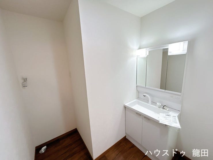 清潔感あふれる白い洗面。隣に洗濯機置き場があり、家事動線もスムーズ