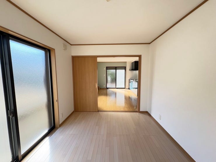 隣り合うお部屋の仕切りを開放することで、より大きな一つの空間として活用できる柔軟な間取りです
温かみのある木目調のフローリングと白い壁紙が、室内を明るく清潔感のある印象にしています。