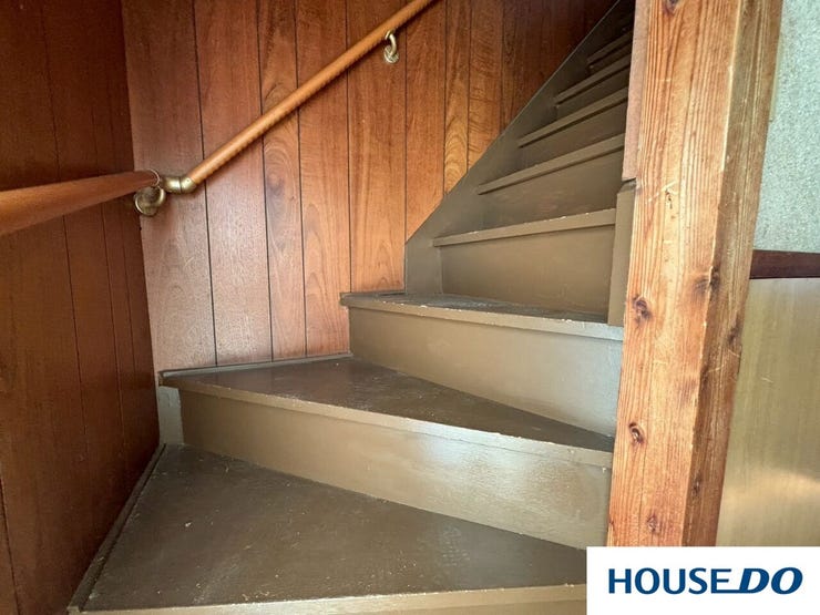 壁のウッドパネルの木目や、階段のマットなブラウンの色合いが、まるで隠れ家やヴィンテージの喫茶店のような「こなれ感」を出しています。最近の既製品にはない、年月を経て馴染んだ深みを感じます。