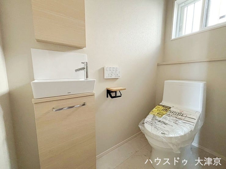 独立した手洗い付きで衛生的なトイレ。落ち着いた木目が柔らかい雰囲気です。自然光が入ることで閉塞感を感じにくく、日中は照明なしでも明るい快適空間になります。収納キャビネットも便利ですね♪