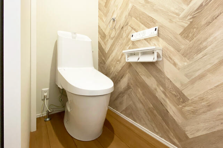 1階トイレは引戸でラクに開閉でき、ヘリンボーン調のアクセントクロスが映えるおしゃれで温かみのある空間です。節水型トイレを採用し、家計にもやさしい仕様です。