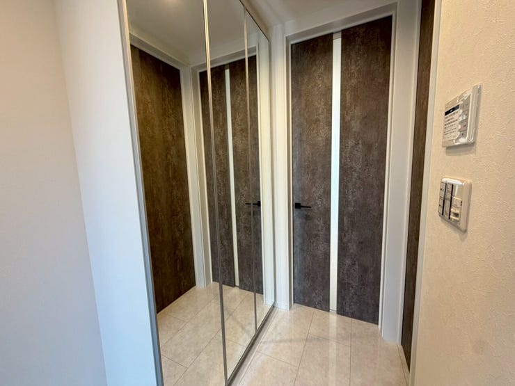 【ENTRANCE】
ストーン調のドアと白い床タイルのコントラストが美しい、洗練されたデザインの玄関。